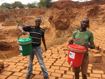 Men holding two of the water filters we gave away. 